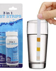 A Hand Holding a Glass Of Water Next To a Bottle Of 3 In 1 Pool And Spa Dip Test Strips 50 Pack